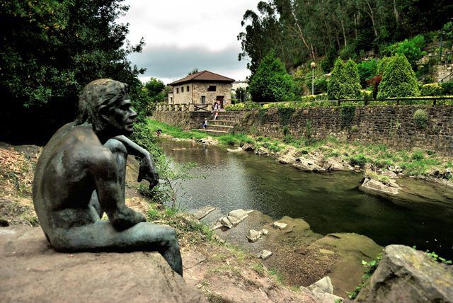 Escultura del hombre-pez a la orilla del río Miera a su paso por Lierganes.